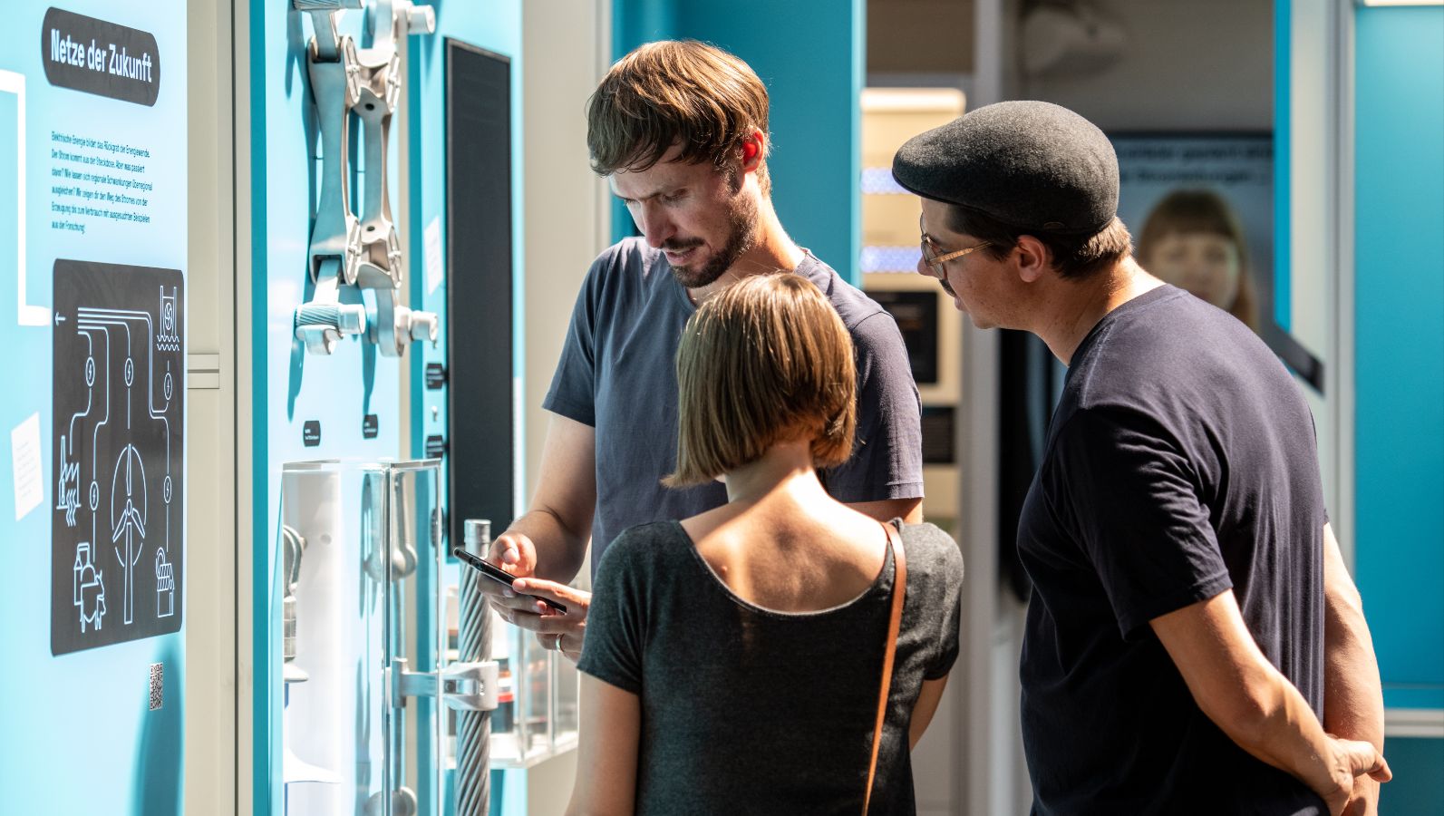 Das Bild zeigt Menschen, die vor einem Model der Ausstellung Power2Change stehen, das sich mit Energienetzen der Zukunft beschäftigt.